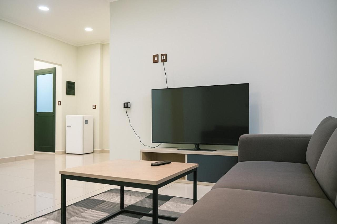 Bright daytime living room at The Prism apartment with smart TV and checkerboard rug