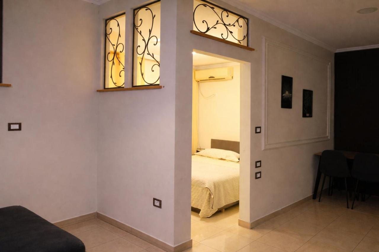 Open-plan living area at The Prism looking through a wrought-iron archway into the bedroom