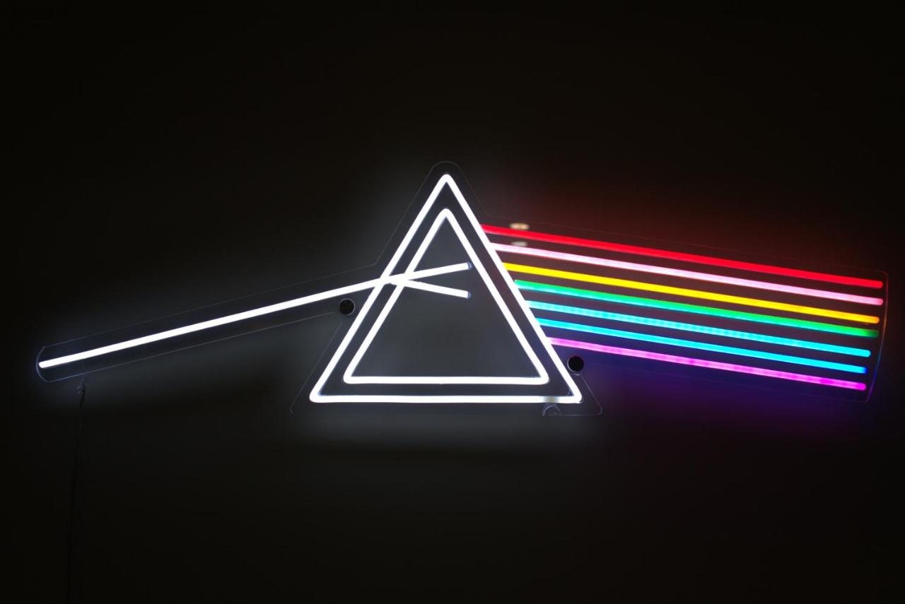 Neon Dark Side of the Moon prism glowing on the wall of The Prism apartment in Tirana